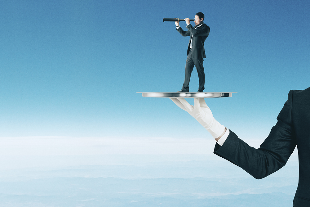 Businessman on tray using telescope to look into the distance on blue sky background with clouds. Success and vision concept