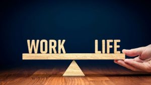 Bilancia in legno che tiene in equilibrio le parole work e life